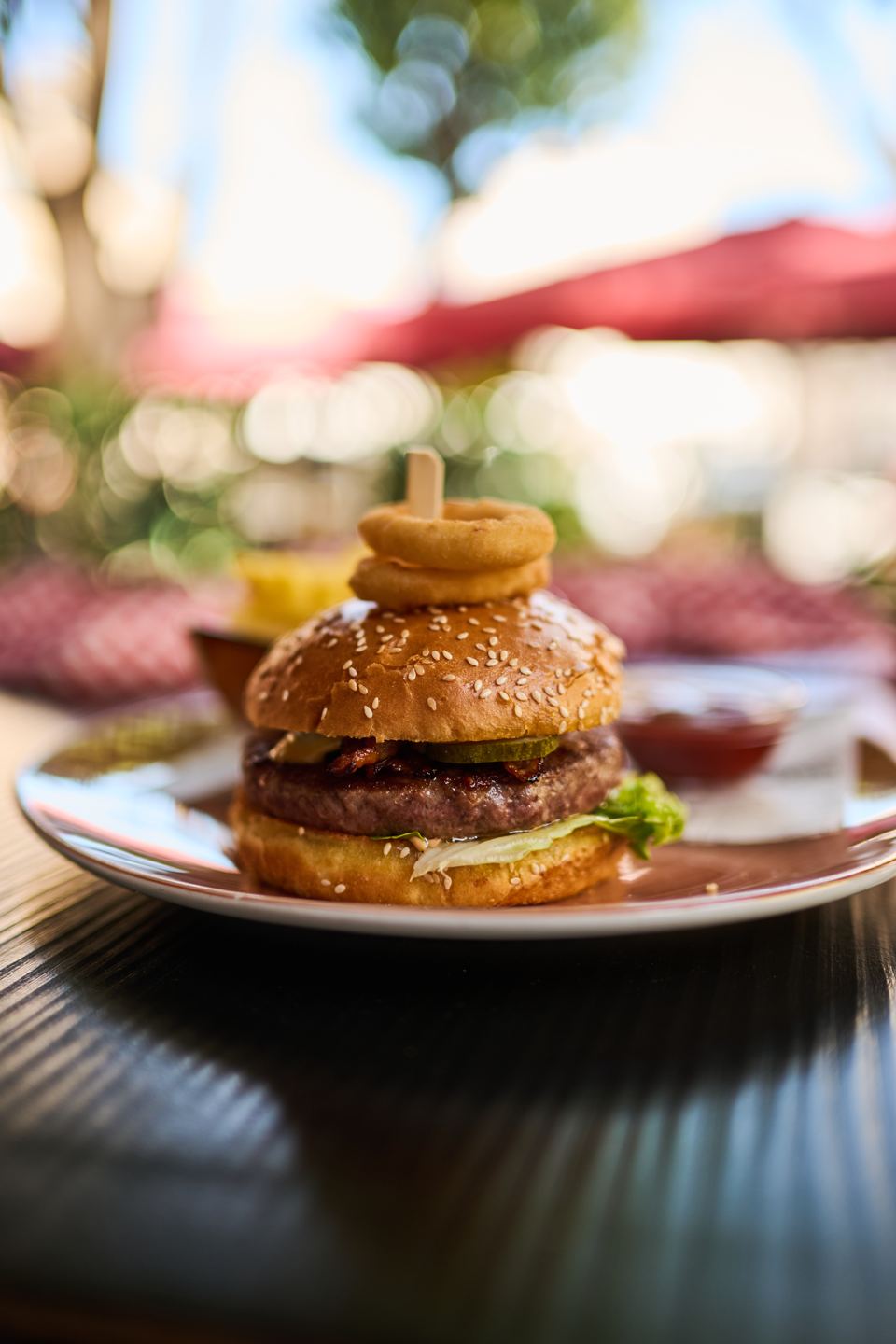 Corso-Burger mit Zwiebelringen auf der Terrasse