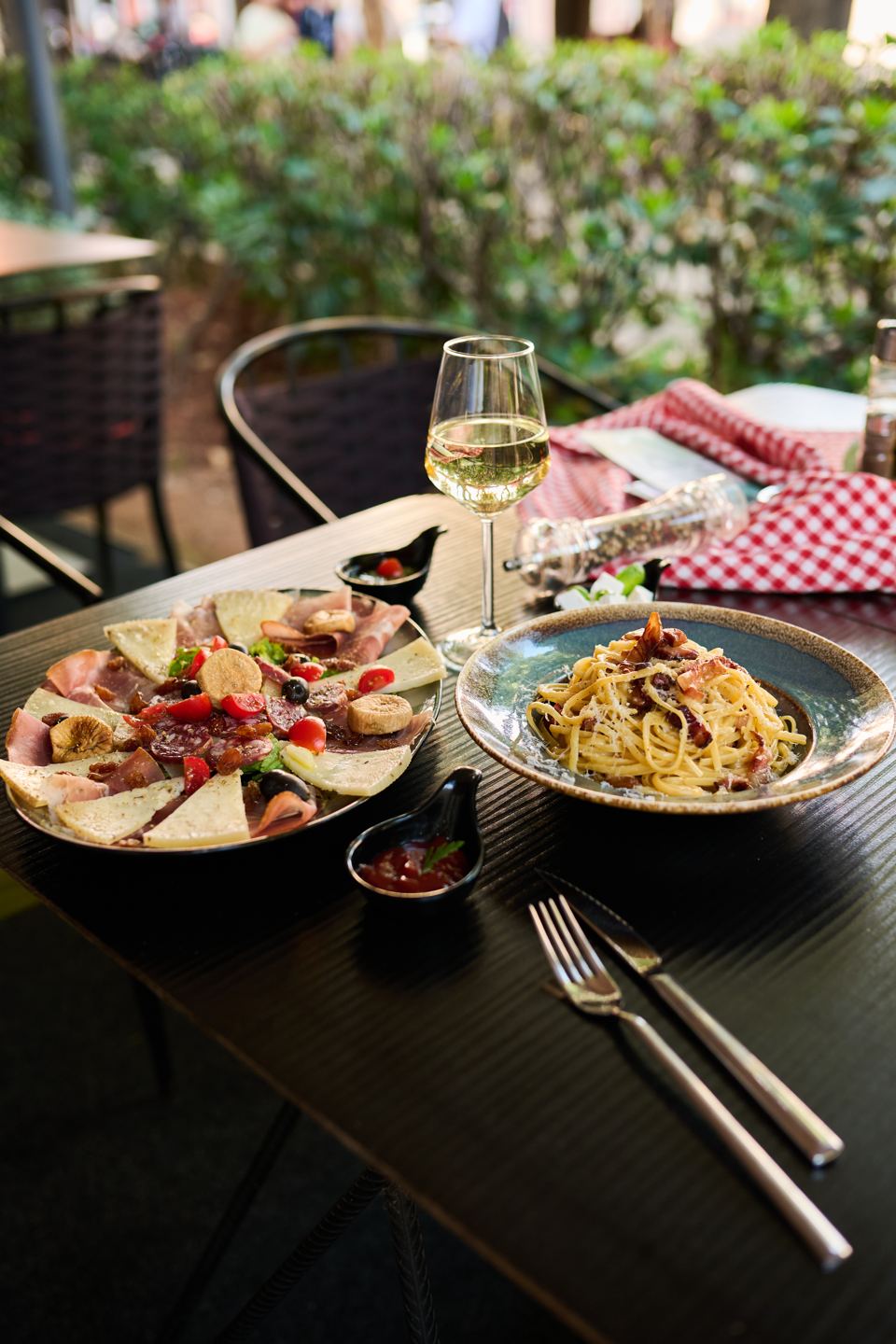 Schinken-Käse-Platte, Pasta Carbonara und Weißwein auf der Terrasse