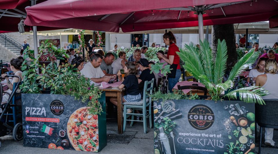 Corso terrace on Giardini in Pula with planters and menu boards